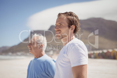 Young man with his father standing at beach