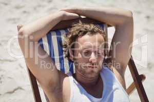 High angle view of young woman relaxaing on lounge chair at beach