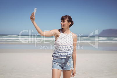 Happy woman talking selfie at beach
