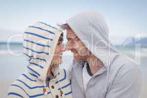 Smiling couple wearing hooded sweater during winter