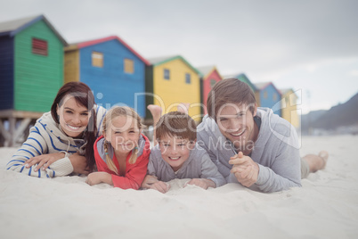 Portrait of smiling family lying on sand