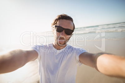 Portrait of young man wearing sunglasses at beach