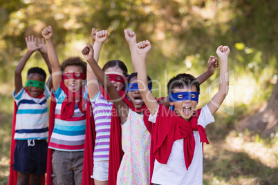 Cheerful friends enjoying while wearing superhero costumes at campsite