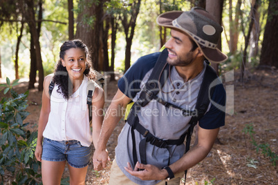 Happy couple holding hands in forest