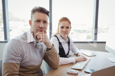 Portrait of executives sitting at desk