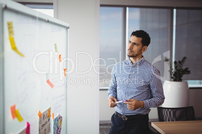 Thoughtful executive looking at whiteboard