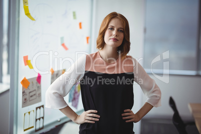 Portrait of confident executive standing with hands on hip