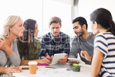 Business people discussing over tablet computer