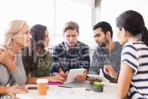 Business people discussing over tablet computer