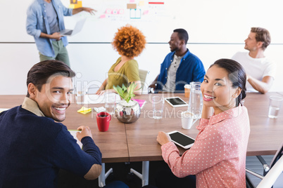 Portrait of colleagues with businessman explaining plan in background