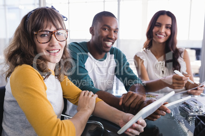 Portrait of smiling creative business colleagues using digital tablet