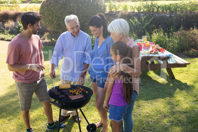 Family talking while preparing barbecue in the park