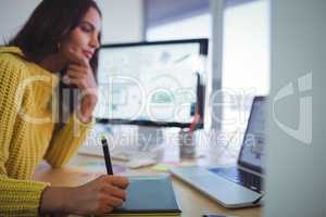Female graphic designer using digitizer in office