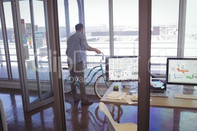 Businessman holding bicycle in office