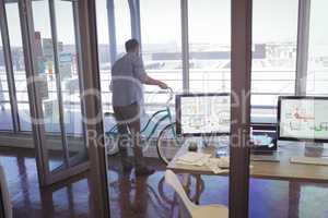 Businessman holding bicycle in office