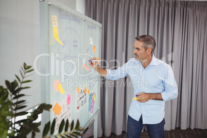 Attentive executive writing on sticky note