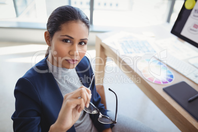 Portrait of confident graphic designer sitting at desk