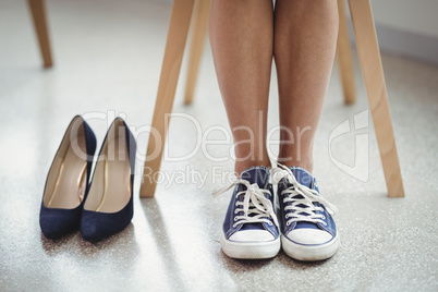 Pair of black shoes kept besides woman in canvas