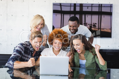 Cheerful business people looking at laptop