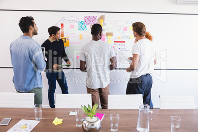 Business colleagues standing by whiteboard