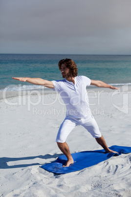 Man performing yoga at beach