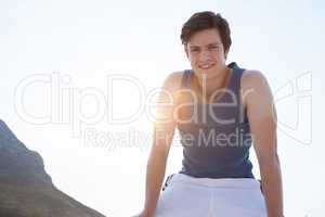 Smiling man taking break after jogging on beach