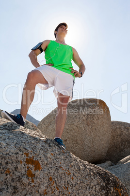 Man standing on rock with hand on hip