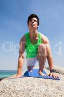 Man performing yoga on rock