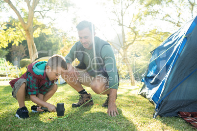 Father and son setting up the tent