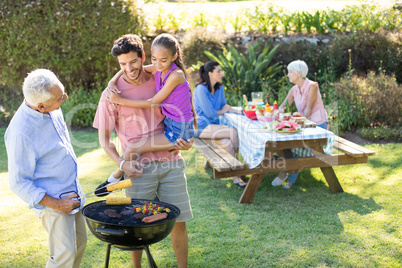 Happy girl, father and grandfather preparing barbecue