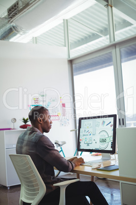 Serious businessman using computer in creative office