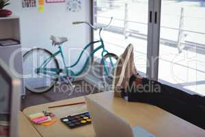 Low section of businessman on desk in office