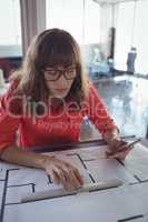 Female interior designer drawing on papers in office