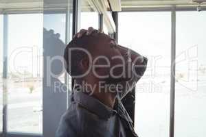 Worried businessman leaning on glass in office