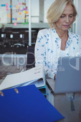Focused businesswoman working on laptop at office