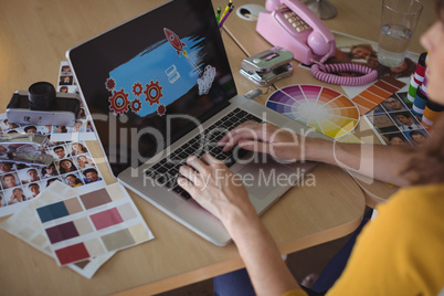 Graphic designer working on laptop at creative office