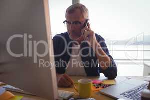 Serious businessman talking on mobile phone at office