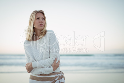 Thoughtful woman looking up at beach