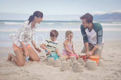 Happy family making sand castle