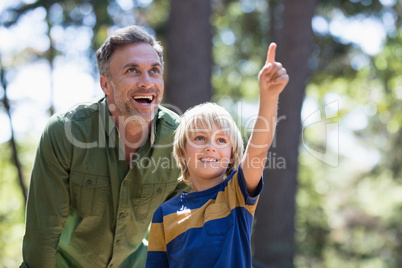 Boy showing something to father while hiking in forest