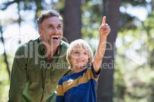 Boy showing something to father while hiking in forest