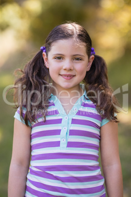 Smiling little girl standing in forest