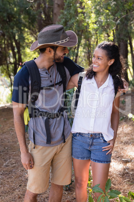 Hiker couple looking at each other in forest