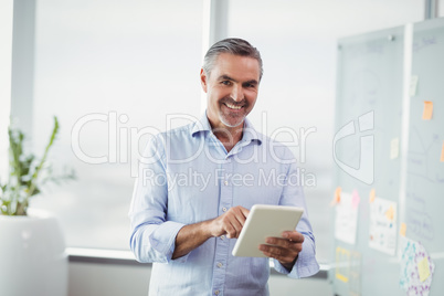 Portrait of smiling executive using digital tablet