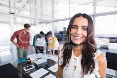 Portrait of businesswoman with colleagues in background
