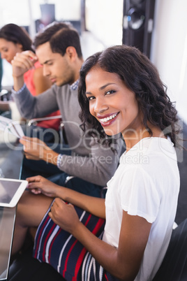 Portrait of smiling businesswoman sitting with colleagues