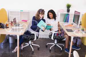 Businesswomen discussing while working in office