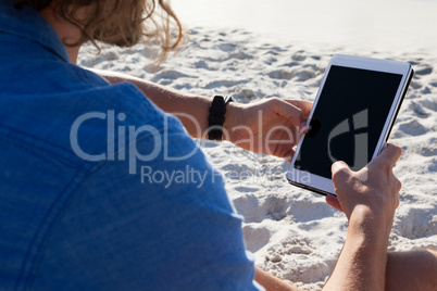 Man using digital tablet on the beach