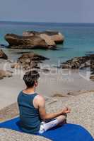 Man performing yoga on rock