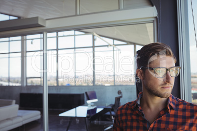 Businessman looking through window in office